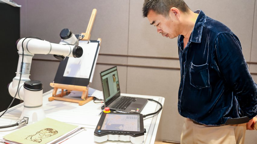 嘉賓體驗(yàn)遨博AI繪畫機(jī)器人。主辦方供圖